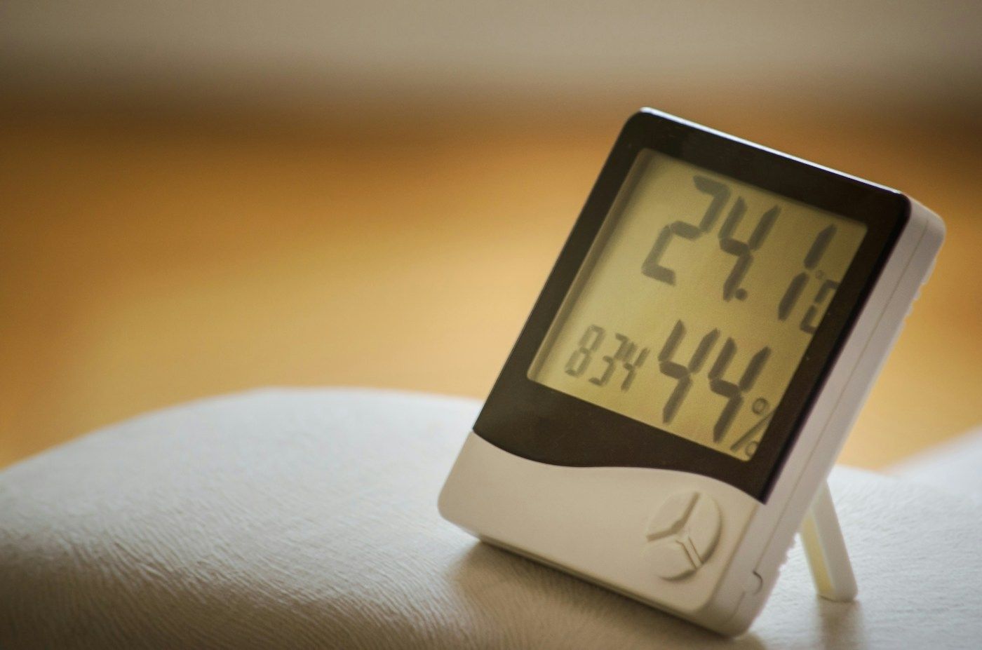 Petit hygromètre numérique posé sur un meuble, affichant la température et l'humidité