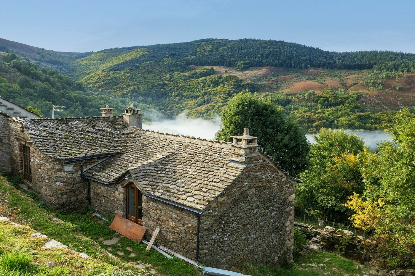 Maisons de pierre aux toits d'ardoise à flanc de colline, dans une région au sous-sol rocheux